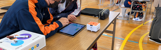 Students using VinciBot and a tablet while learning with coding robots for kids